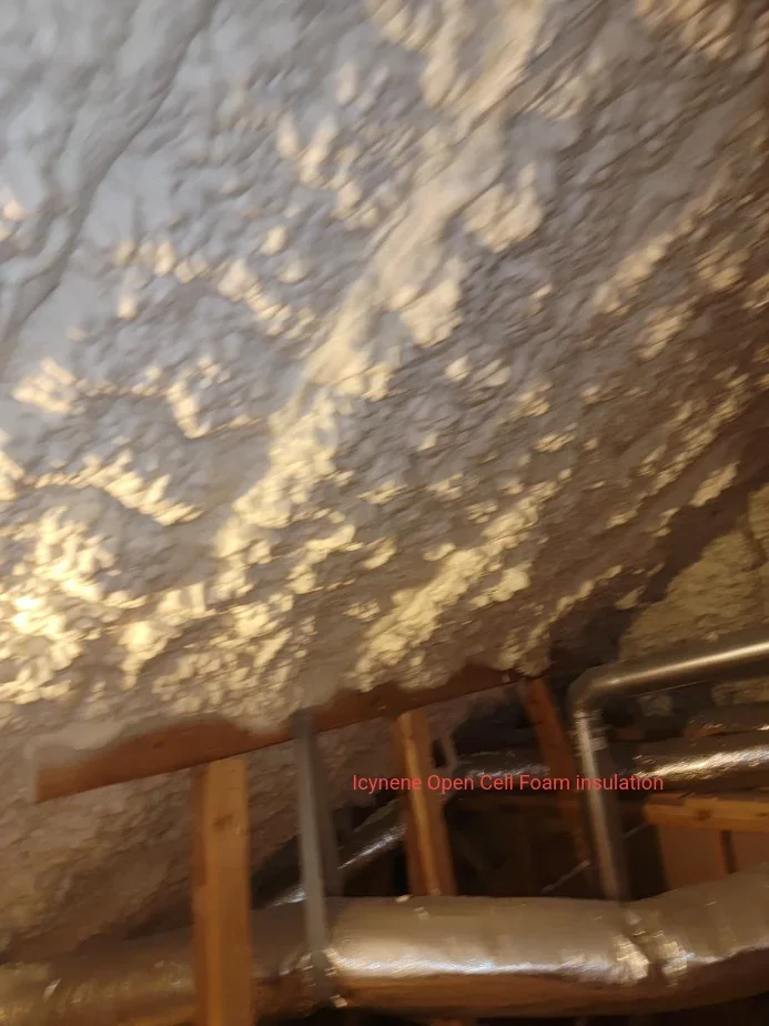 Icynene open cell foam insulation sprayed on attic roof decking with wooden framing visible