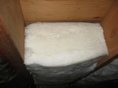 Fiberglass batt insulation installed between wooden wall framing